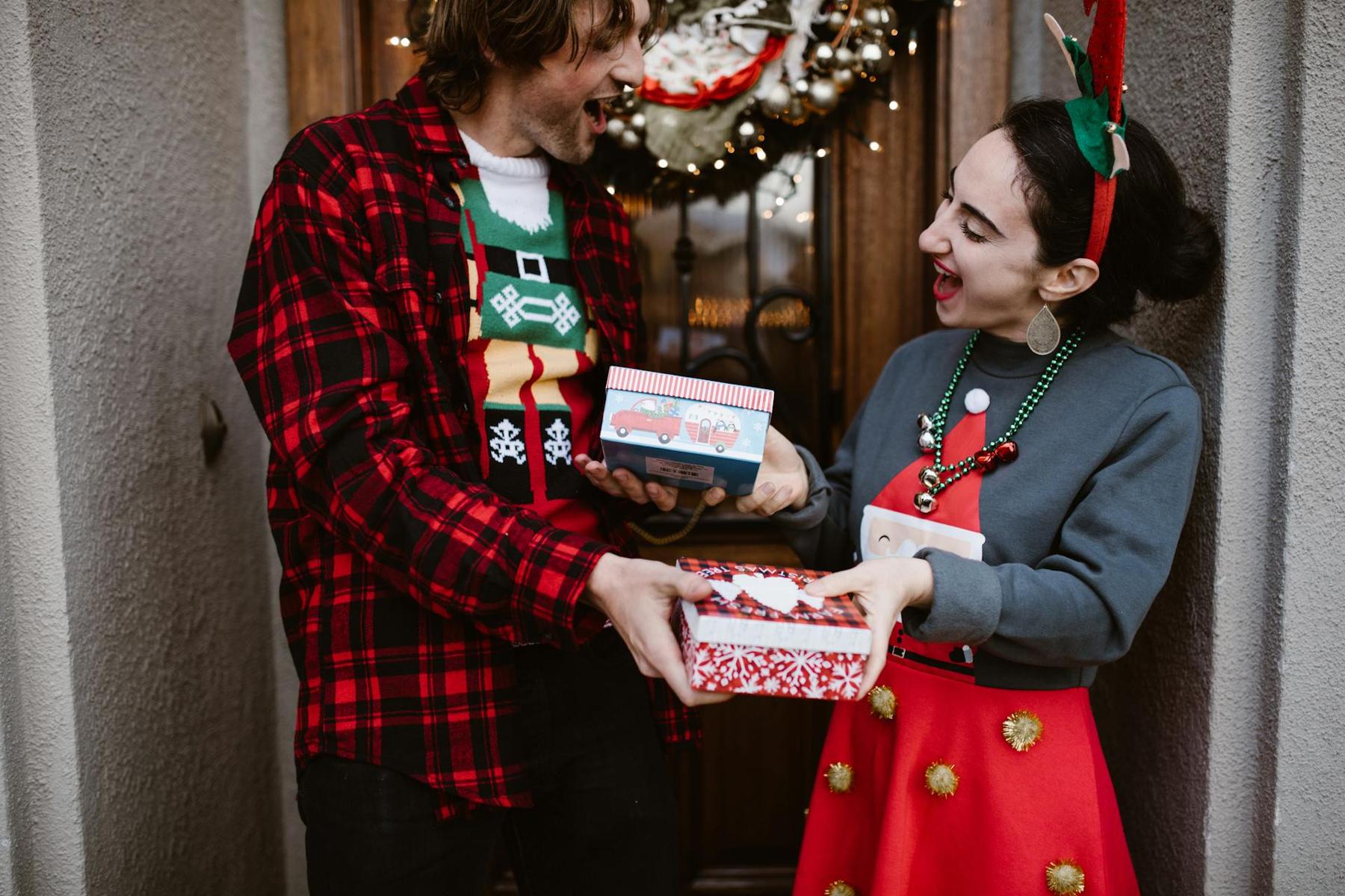 Zwei Personen geben sich gegenseitig Weihnachtsgeschenke und freuen sich